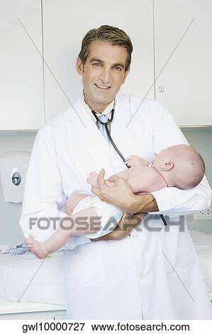 Doctor carrying a newborn baby View Large Photo Image Stock Photo - Doctor carrying a newborn baby. Fotosearch