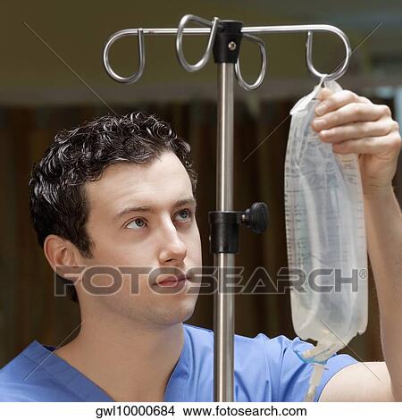 Doctor checking a saline drip View Large Photo Image Picture - Doctor checking a saline drip. Fotosearch