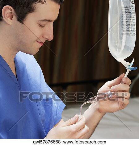 Stock Photo - Doctor checking a saline drip. Fotosearch