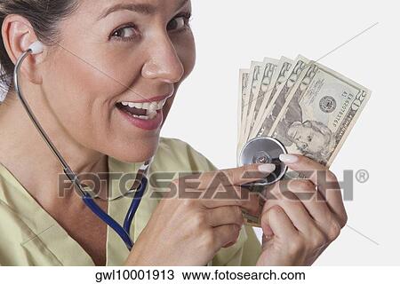 Doctor checking currency notes with a stethoscope View Large Photo Image Stock Image - Doctor checking currency notes with a stethoscope. Fotosearch