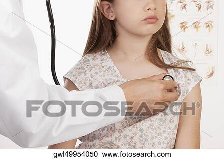 Stock Image - Doctor examining a girl with a stethoscope. Fotosearch