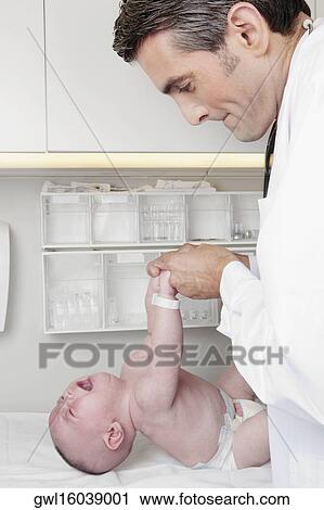 Doctor examining a newborn baby View Large Photo Image Stock Image - Doctor examining a newborn baby. Fotosearch