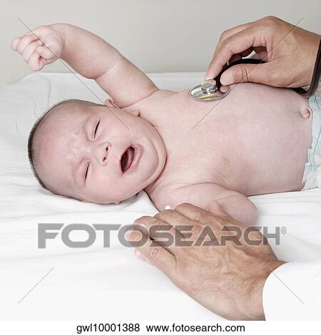 Doctor examining a newborn baby View Large Photo Image Stock Photo - Doctor examining a newborn baby. Fotosearch