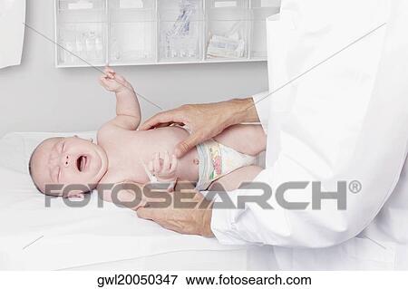 Doctor examining a newborn baby View Large Photo Image Stock Photo - Doctor examining a newborn baby. Fotosearch