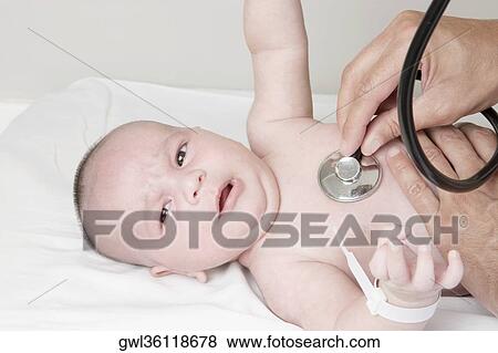 Doctor examining a newborn baby View Large Photo Image Stock Photo - Doctor examining a newborn baby. Fotosearch