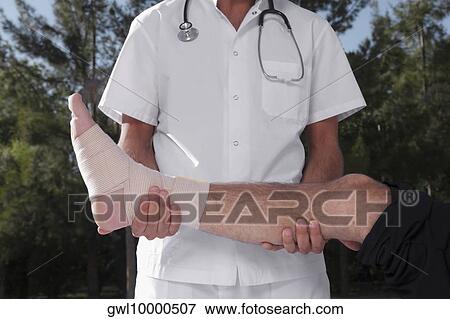 Doctor examining a patient's foot View Large Photo Image Stock Photo - Doctor examining a patient's foot. Fotosearch