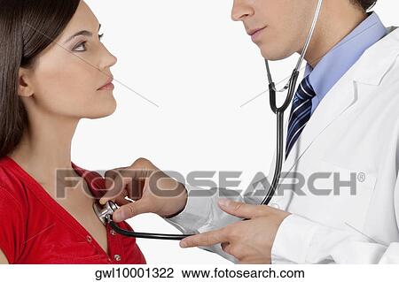 Doctor examining a woman with a stethoscope View Large Photo Image Stock Image - Doctor examining a woman with a stethoscope. Fotosearch