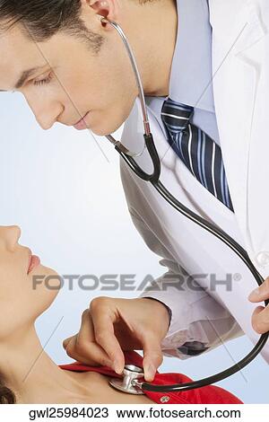 Doctor examining a woman with a stethoscope View Large Photo Image Stock Image - Doctor examining a woman with a stethoscope. Fotosearch