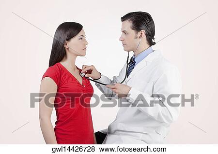 Doctor examining a woman with a stethoscope View Large Photo Image Stock Photo - Doctor examining a woman with a stethoscope. Fotosearch