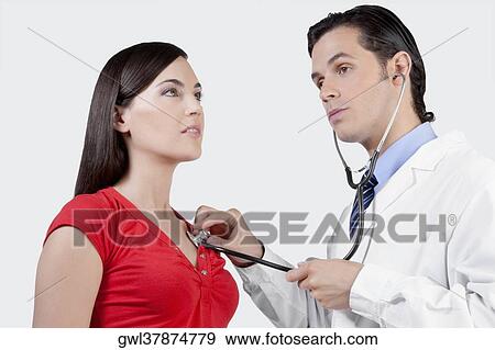 Doctor examining a woman with a stethoscope View Large Photo Image Stock Photo - Doctor examining a woman with a stethoscope. Fotosearch