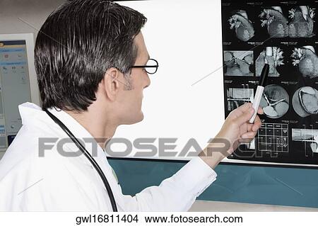 Doctor examining MRI report View Large Photo Image Picture - Doctor examining MRI report. Fotosearch