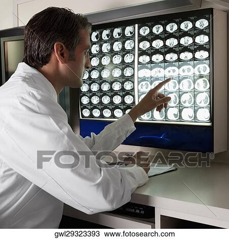 Doctor examining MRI report View Large Photo Image Stock Image - Doctor examining MRI report. Fotosearch