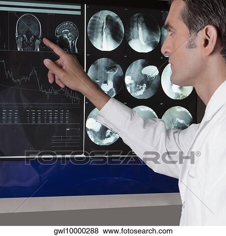 Doctor examining MRI report View Large Photo Image Stock Photo - Doctor examining MRI report. Fotosearch