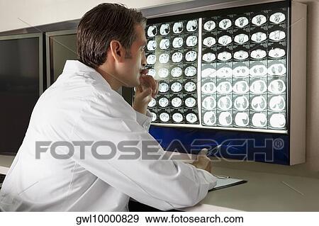 Doctor examining MRI report View Large Photo Image Stock Photo - Doctor examining MRI report. Fotosearch