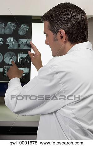 Stock Photo - Doctor examining MRI report. Fotosearch