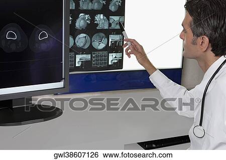 Stock Photograph - Doctor examining MRI report. Fotosearch