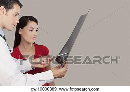 Stock Photo - Doctor explaining x-ray report to a patient. Fotosearch