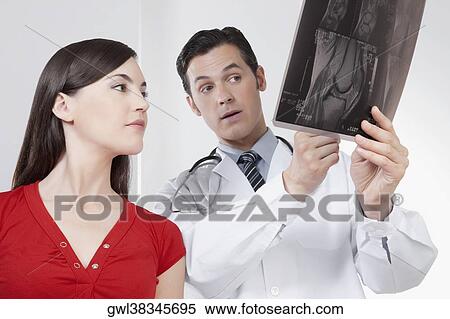 Doctor explaining x-ray report to a patient View Large Photo Image Stock Photography - Doctor explaining x-ray report to a patient. Fotosearch