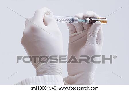 Doctor filling hypodermic needle from bottle View Large Photo Image Stock Image - Doctor filling hypodermic needle from bottle. Fotosearch
