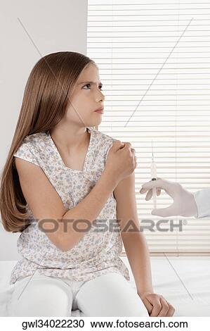 Doctor giving an injecting to a girl View Large Photo Image Stock Image - Doctor giving an injecting to a girl. Fotosearch
