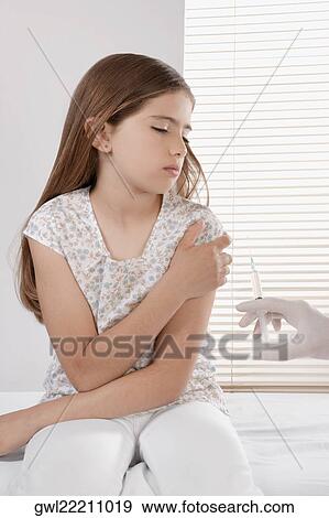 Doctor giving an injecting to a girl View Large Photo Image Stock Photo - Doctor giving an injecting to a girl. Fotosearch