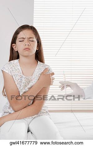 Doctor giving an injecting to a girl View Large Photo Image Stock Photo - Doctor giving an injecting to a girl. Fotosearch