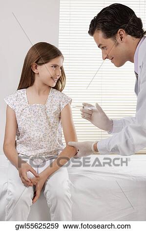 Stock Photo - Doctor giving an injecting to a girl. Fotosearch
