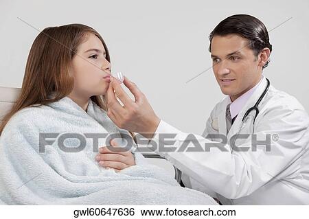 Doctor giving medicine to a girl View Large Photo Image Stock Photograph - Doctor giving medicine to a girl. Fotosearch