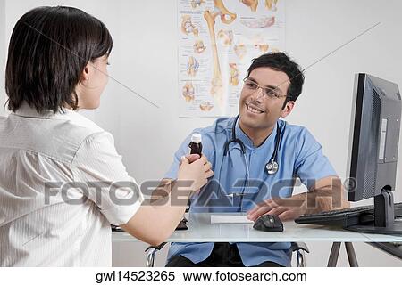 Doctor giving medicine to a patient View Large Photo Image Stock Photography - Doctor giving medicine to a patient. Fotosearch