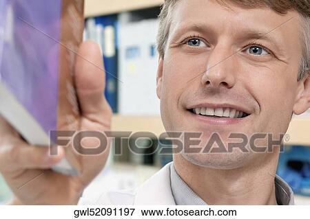 Stock Photo - Doctor holding a book and smiling. Fotosearch