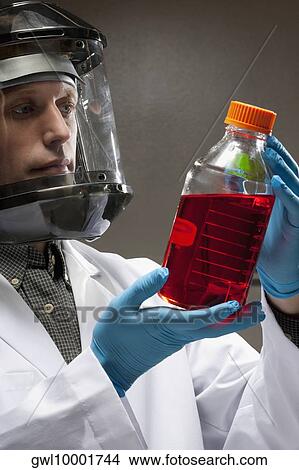 Doctor holding a bottle of solution in a laboratory View Large Photo Image Picture - Doctor holding a bottle of solution in a laboratory. Fotosearch