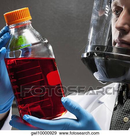 Doctor holding a bottle of solution in a laboratory View Large Photo Image Stock Photo - Doctor holding a bottle of solution in a laboratory. Fotosearch