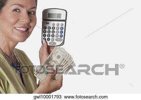 Doctor holding a calculator and currency notes View Large Photo Image Stock Image - Doctor holding a calculator and currency notes. Fotosearch