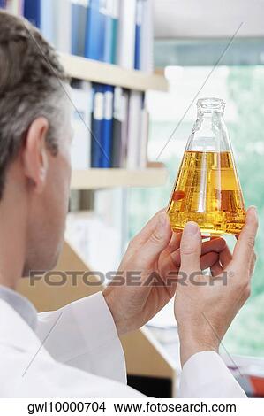 Doctor holding a conical flask in a laboratory View Large Photo Image Picture - Doctor holding a conical flask in a laboratory. Fotosearch