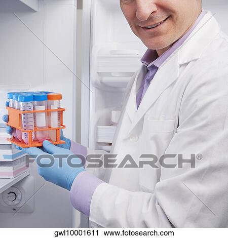 Stock Image - Doctor holding medical samples in a laboratory. Fotosearch