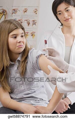 Stock Image - Doctor injecting a girl. Fotosearch