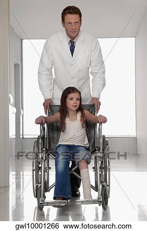 Doctor pushing a patient in a wheelchair View Large Photo Image Stock Photograph - Doctor pushing a patient in a wheelchair. Fotosearch
