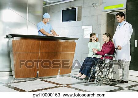 Doctor pushing a woman in a wheelchair View Large Photo Image Stock Image - Doctor pushing a woman in a wheelchair. Fotosearch