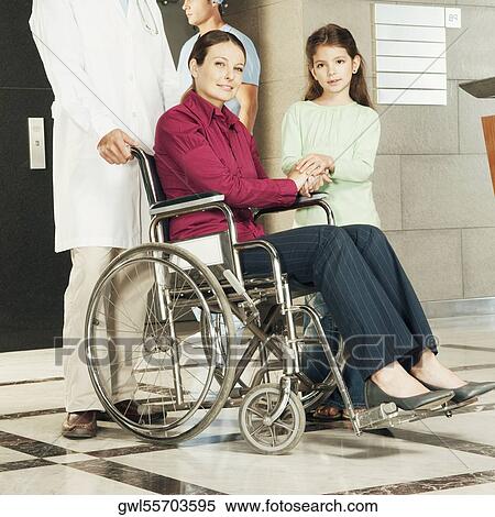 Doctor pushing a woman in a wheelchair View Large Photo Image Stock Photography - Doctor pushing a woman in a wheelchair. Fotosearch
