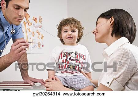 Doctor reading a baby boy's temperature sitting with his mother View Large Photo Image Picture - Doctor reading a baby boy's temperature sitting with his mother. Fotosearch