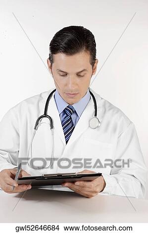 Doctor reading a report View Large Photo Image Picture - Doctor reading a report. Fotosearch