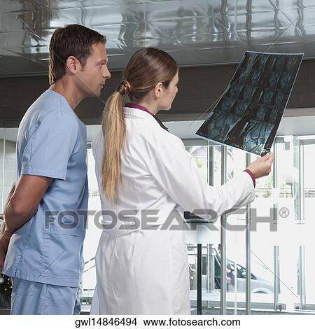 Doctor showing MRI scan to a male nurse View Large Photo Image Picture - Doctor showing MRI scan to a male nurse. Fotosearch