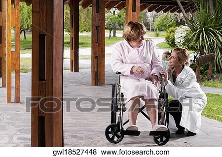 Doctor sitting near a patient and smiling View Large Photo Image Stock Photo - Doctor sitting near a patient and smiling. Fotosearch
