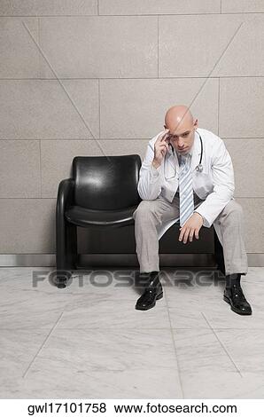 Doctor sitting on a chair and looking stressed View Large Photo Image Stock Photo - Doctor sitting on a chair and looking stressed. Fotosearch
