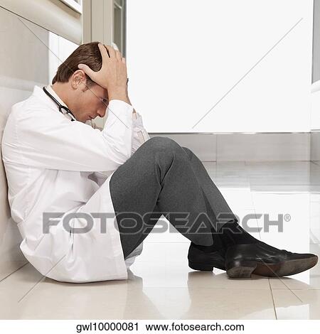 Doctor sitting on the floor looking depressed View Large Photo Image Stock Image - Doctor sitting on the floor looking depressed. Fotosearch