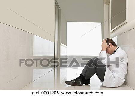 Doctor sitting on the floor looking depressed View Large Photo Image Stock Photography - Doctor sitting on the floor looking depressed. Fotosearch