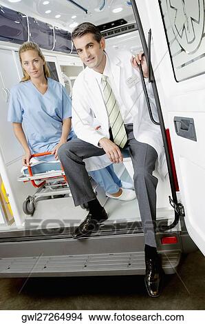 Doctor sitting with a female nurse in an ambulance View Large Photo Image Picture - Doctor sitting with a female nurse in an ambulance. Fotosearch