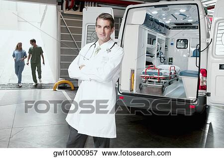 Doctor standing in front of an ambulance View Large Photo Image Stock Photo - Doctor standing in front of an ambulance. Fotosearch