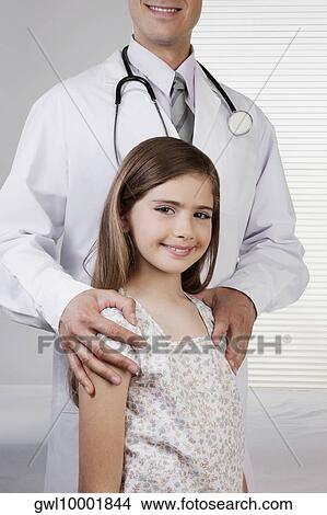 Doctor standing with a girl View Large Photo Image Picture - Doctor standing with a girl. Fotosearch