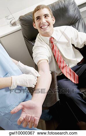 Doctor taking blood sample of a man View Large Photo Image Stock Photo - Doctor taking blood sample of a man. Fotosearch